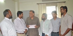 PFI chief KM Shareef giving a cheque of Rs 10 lakh to Uttarakhand CM